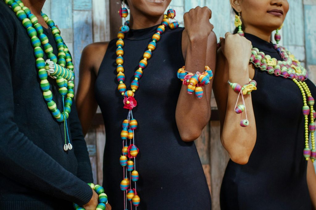Vibrant necklaces and bracelets showcased on models in stylish attire.